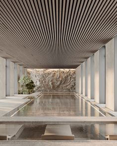 an indoor swimming pool in the middle of a room with white walls and flooring