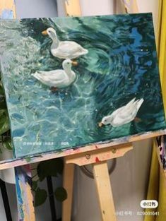 two ducks are swimming in the water on an easel