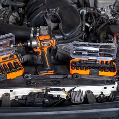 an assortment of tools sitting on top of a car's engine bay in the process of being installed