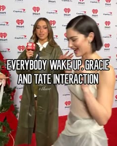 two women standing in front of a red carpet with the words everybody wake up, grace and tate interaction