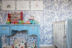 a baby's room with blue and white wallpaper