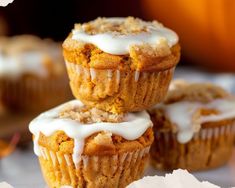 three pumpkin muffins with icing on top