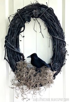 a black bird sitting on top of a nest in front of a white door frame