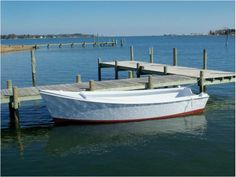 a white boat is tied up to the dock