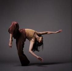 a woman is doing a handstand in the air with her arms stretched out