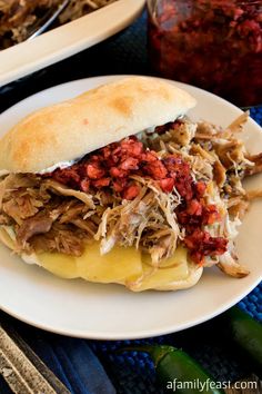 a pulled pork sandwich on a white plate