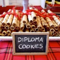 there is a sign that says diploma cookies in front of some cinnamon rolls and bananas