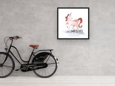 a bicycle parked in front of a wall with a painting on it