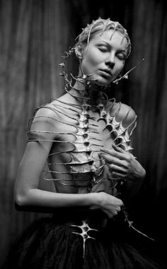 a woman in a dress with metal wire attached to her chest