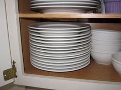 white plates stacked on top of each other in a cabinet