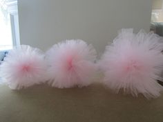 three fluffy pink pom poms sitting on top of a table