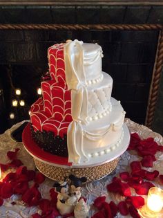 a three tiered wedding cake sitting on top of a table with candles around it