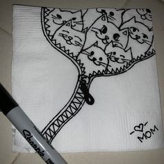 a white napkin with black cat designs on it and a marker next to the napkin