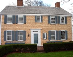 a brown brick house with blue shutters on the windows