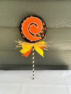 a candy lollipop sitting on top of a white table next to a gray wall