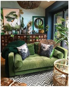 a living room filled with lots of green furniture and plants on top of the couch