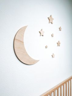 the moon and stars are hanging on the wall next to the crib in this nursery room