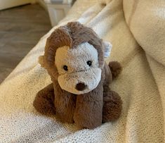 a stuffed monkey sitting on top of a bed