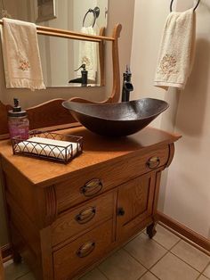 a bathroom with a sink, mirror and towel rack in it's center area