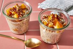 two jars filled with oatmeal and fruit on top of a pink tile floor