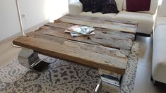 a coffee table made out of wooden planks in a living room with white couches