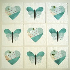 nine pieces of paper are arranged in the shape of heart shaped shapes with blue and white fabric