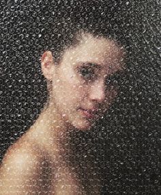 a close up of a person behind a window covered in rain drops and water droplets