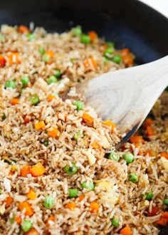 rice and vegetables being cooked in a skillet