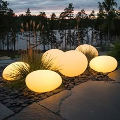 some lights that are sitting on the ground in front of grass and rocks with trees in the background