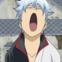 a man with white hair and blue eyes yawns in front of the camera