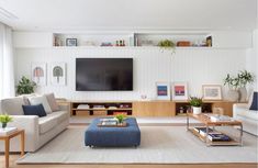 a living room filled with furniture and a flat screen tv mounted to the side of a wall