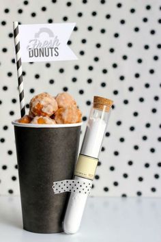 there is a cup with donuts in it next to a bottle and a straw