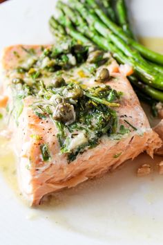 a white plate topped with salmon and asparagus