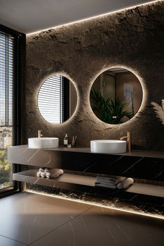 a bathroom with two sinks and three round mirrors on the wall next to each other