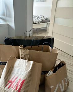 several brown paper bags sitting on top of a wooden floor