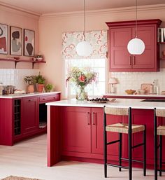 a kitchen with red cabinets and white counter tops