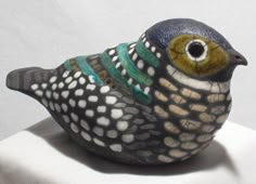 a ceramic bird sitting on top of a white surface