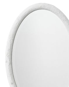 a white round mirror on the wall with an abstract design in the middle and bottom