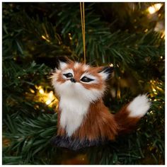 an ornament shaped like a fox hanging from a christmas tree