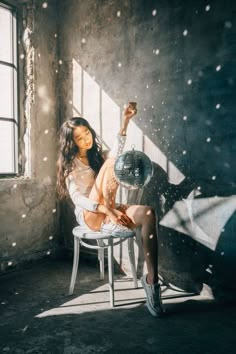 a woman is sitting in a chair and posing for the camera