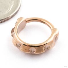 a gold ring sitting next to a coin