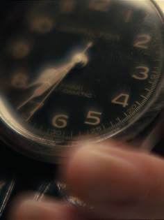 a close up of a person holding an analog watch