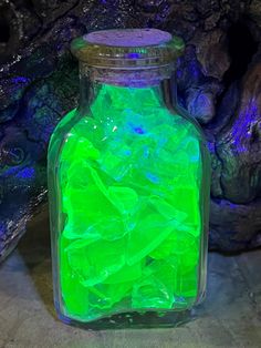 a bottle filled with green liquid sitting on top of a table