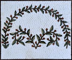 a white and brown mosaic with leaves on it's side, in the center