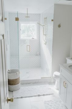 a white bathroom with a glass shower door