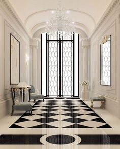 an elegant hallway with black and white flooring, chandelier and two chairs