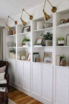 a living room filled with lots of white bookshelves covered in plants and potted plants