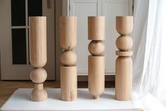 three wooden poles are stacked on top of each other in front of a white door