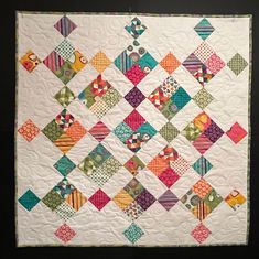 a colorful quilt is hanging on the wall