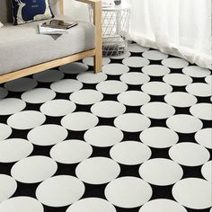 a living room with black and white polka dot rugs on the floor next to a couch